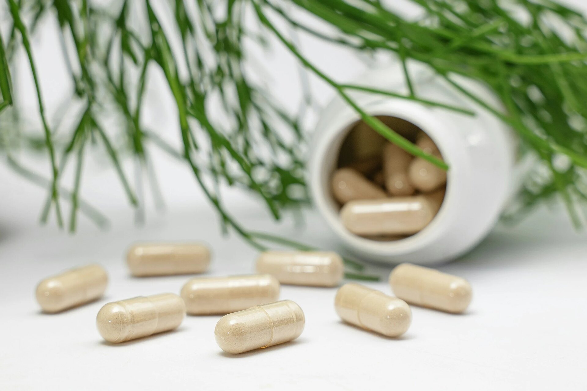 Supplement bottles and capsules on a pale surface